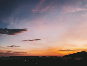Scenic view of silhouette mountains against romantic sky at sunset