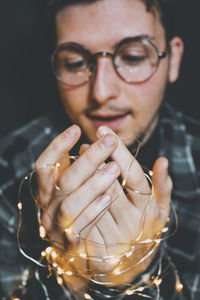 Close-up of man holding string light