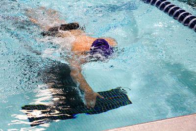 High angle view of shirtless male swimmer swimming in pool