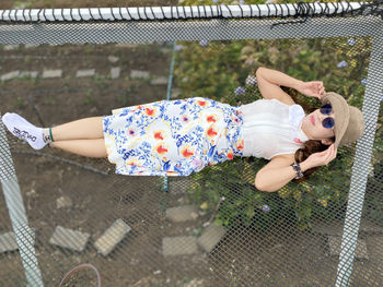 High angle view of girl relaxing on fence