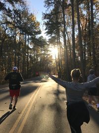 Rear view of people on road in forest