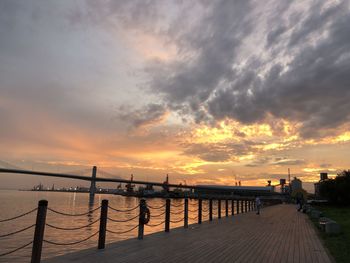 Pier over sea against sky during sunset