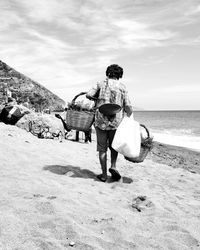 Rear view of couple walking on beach