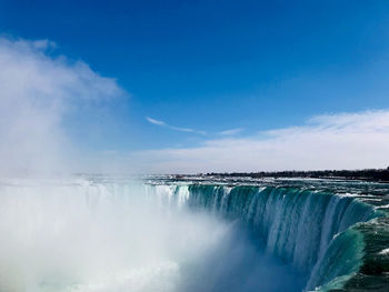 Panoramic view of waterfall against sky