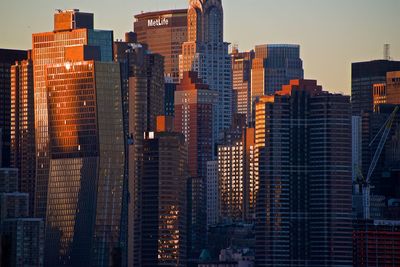 Modern buildings in city against sky at dusk