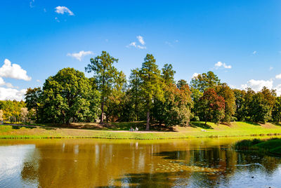 Scenic view of lake by trees against sky