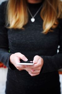 Midsection of woman using mobile phone