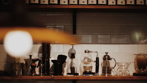 Illuminated bottles on shelf at home