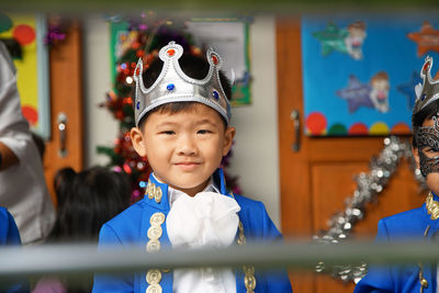 Portrait of smiling boy wearing crown while standing in party