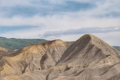 Landscape of barren tan colored rolling hills in colorado