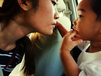 Close-up of woman looking at son in car