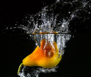Close-up of fruit on water against black background