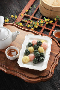 Three color kkultteok is ball shaped rice cake filled with honey and sesame syrup, 