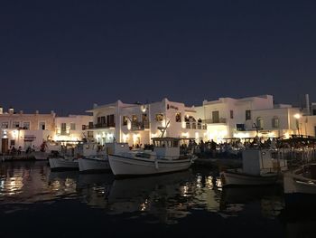 Sailboats moored in city at night