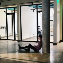 Man sitting on floor by window