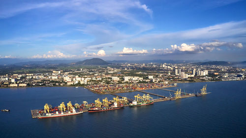 Aerial view of city by sea against sky