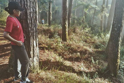 Woman standing on tree trunk