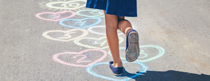 Low section of woman standing on road