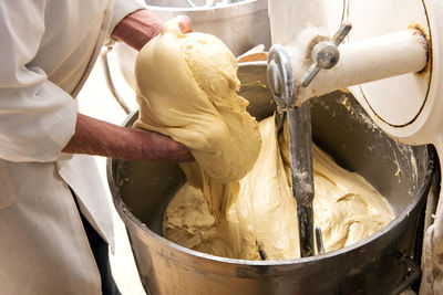 Midsection of male chef preparing dough in kitchen