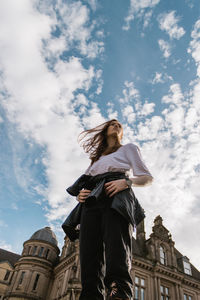 Low angle view of woman against building