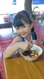 Portrait of cute girl sitting on table