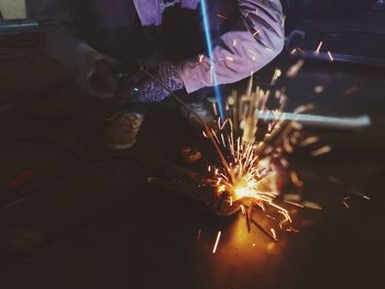 Low section of man crouching by sparks