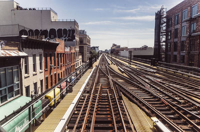 High angle view of railroad tracks amidst buildings against sky in city