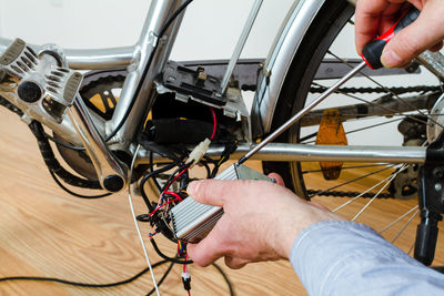 Cropped hands of worker repairing bicycle