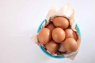 Close-up of eggs in basket against white background