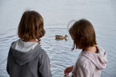 Rear view of two women on water