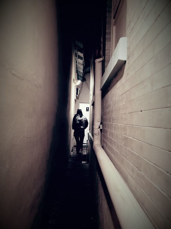 darkness, light, black, white, architecture, snapshot, wall - building feature, built structure, full length, shadow, one person, tunnel, night, men, walking, adult, city, rear view, monochrome, transportation, wall, black and white, lifestyles, the way forward, alley, building, indoors, infrastructure, footpath, camera, street, dark, motion