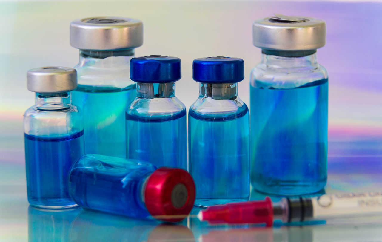 CLOSE-UP OF DRINKING GLASS WITH BOTTLES