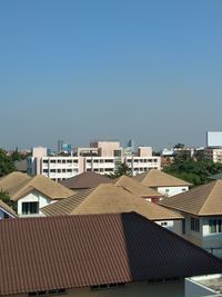 Buildings in city against clear blue sky