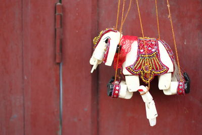 Close-up of puppet hanging against wooden wall