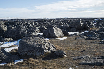 Rocks on land against sky during winter