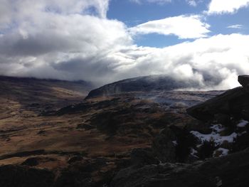 Scenic view of mountains against cloudy sky