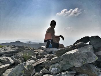 Full length of man standing on rock against sky