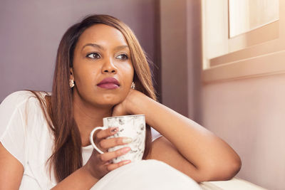 Portrait of young woman sitting at home