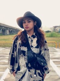 Portrait of young woman wearing hat while standing outdoors