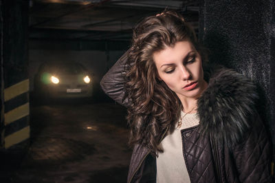 Beautiful woman standing against column in parking garage