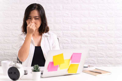 Businesswoman suffering from flu and cold while sitting in office