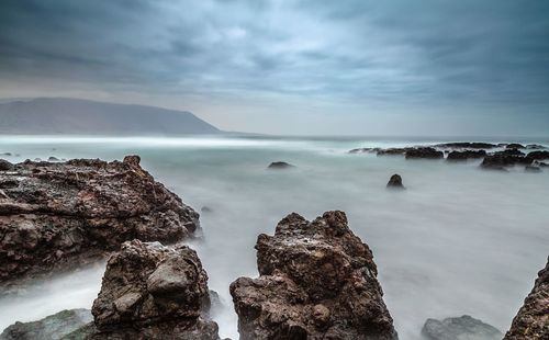 Panoramic view of sea and rocks against sky