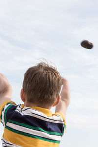 Low angle view of boy against sky