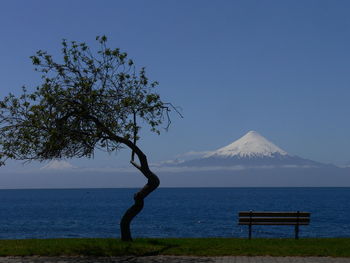 Scenic view of lake by osorno volcano against clear blue sky