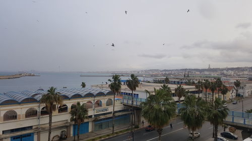 View of city by sea against sky