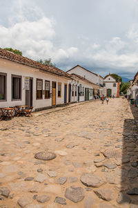 Overview of cobblestone street with old houses under cloudy sky in paraty, brazil