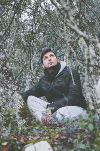 Full length of man sitting in forest