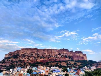 Low angle view of rock formation against cloudy sky