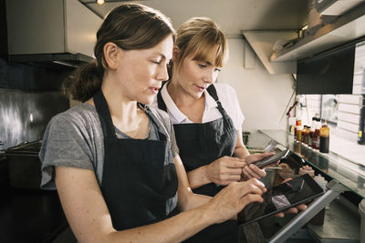 Female chefs using technology in food truck