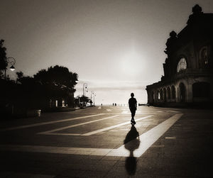 Silhouette of woman walking in city